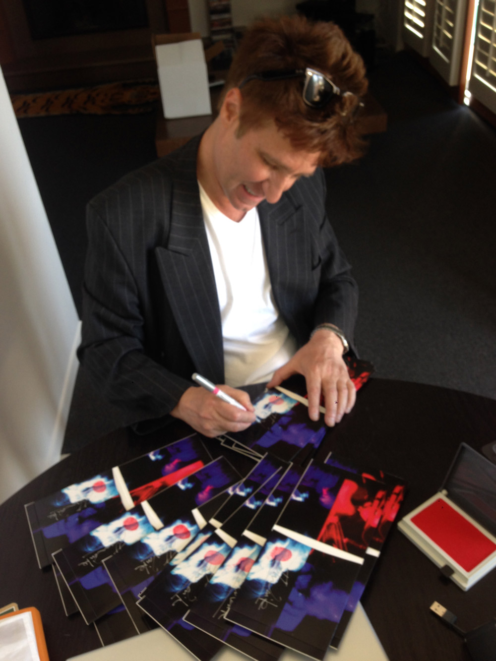 John signing the latest batch of "John Waite - BEST" CDs purchased by fans in the official store.